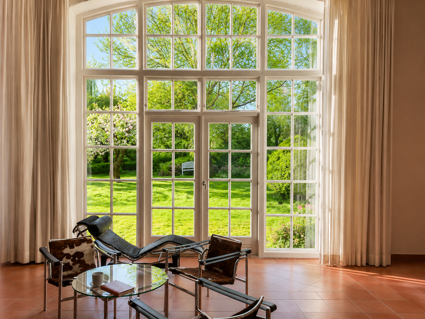 Wohnhalle mit großer Fensterfront zum Garten